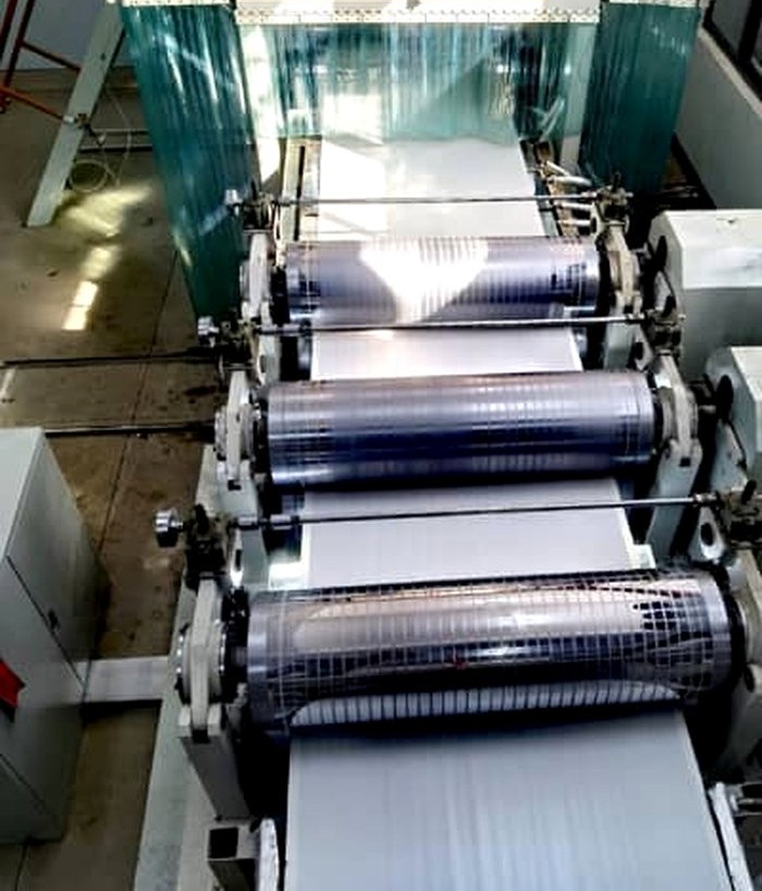 Composite sheet running through industrial rollers